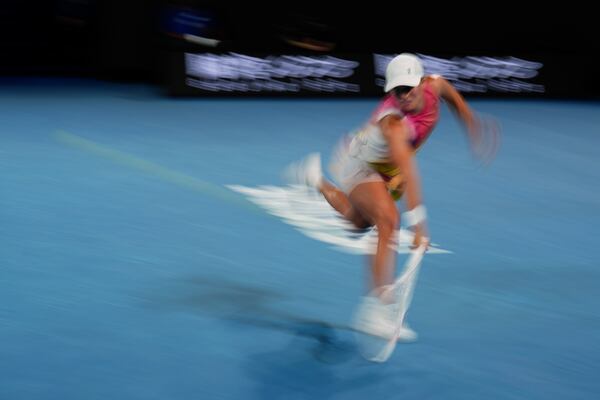 Iga Swiatek of Poland plays a backhand return to Madison Keys of the U.S. during their semifinal match at the Australian Open tennis championship in Melbourne, Australia, Thursday, Jan. 23, 2025. (AP Photo/Vincent Thian)