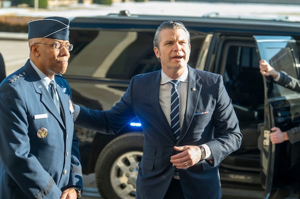 Defense Secretary Pete Hegseth, right, pats Chairman of the Joint Chiefs of Staff Gen. Charles Q. Brown Jr., on his shoulder as he answers questions from reporters after arriving at the Pentagon, Monday, Jan. 27, 2025 in Washington. (AP Photo/Kevin Wolf)