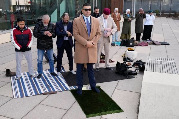 Hafsa Haider, front, Communications Coordinator of Council on American-Islamic Relations, prays with members outside the Will County Courthouse where a jury found defendant Joseph Czuba found guilty of murder and hate crime charges, Friday, Feb. 28, 2025, in Joliet, Ill. (AP Photo/Nam Y. Huh)