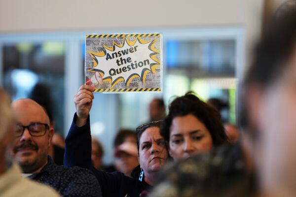 Liz Oxford holds up a sign during a town hall event with Rep. Marie Gluesenkamp Perez, D-Wash., at Centralia College, Tuesday, April 22, 2025, in Centralia, Wash. (AP Photo/Lindsey Wasson)