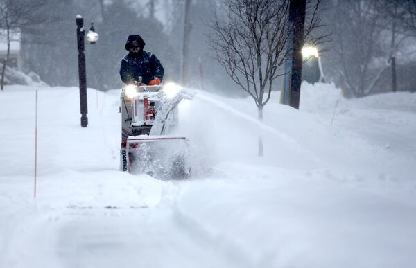 A crew clears snow during a storm in Portsmouth, N.H., Thursday, Feb. 6, 2025. (AP Photo/Caleb Jones)