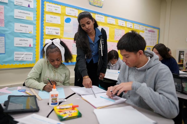 A tutor helps students at Benjamin O. Davis Middle School in Compton, Calif., Thursday, Feb. 6, 2025. (AP Photo/Eric Thayer)