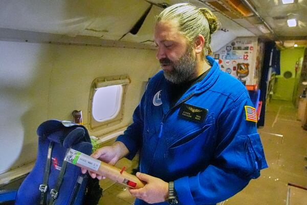 NOAA engineer Stephen Paul holds a tube that is dropped during a hurricane from the Lockheed WP-3D Orion aircraft to collect weather date at the NOAA Aircraft Operations Center Tuesday, May 6, 2025, in Lakeland, Fla. (AP Photo/John Raoux)
