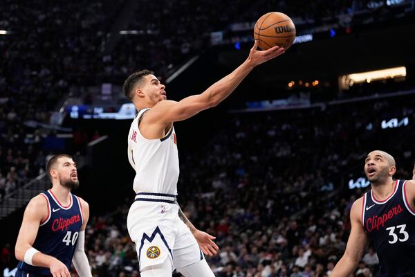 Denver Nuggets forward Michael Porter Jr., center, shoots as Los Angeles Clippers center Ivica Zubac, left, and forward Nicolas Batum defend during the second half in Game 6 of an NBA basketball first-round playoff series Thursday, May 1, 2025, in Inglewood, Calif. (AP Photo/Mark J. Terrill)