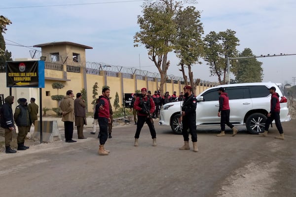 Security guards watch a vehicle carrying Bushra Bibi, wife of imprisoned former Prime Minister Imran Khan, as she arrives to hear verdict on corruption case in a court specially set up in Adiyala prison, in Rawalpindi, Pakistan, Friday, Jan. 17, 2025. (AP Photo/W.K. Yousufzai)