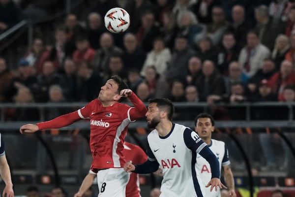 AZ Alkmaar's Jordy Clasie, left, jumps for the ball with Tottenham's Rodrigo Bentancur during the Europa League round of 16 first leg soccer match between AZ Alkmaar and Tottenham Hotspur at the AFAS Stadium, in Alkmaar, Netherlands, Thursday, March 6, 2025. (AP Photo/Patrick Post)