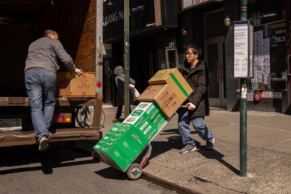 FILE - Delivery workers carry boxes outside a grocery store in the Chinatown neighborhood, Wednesday, April 9, 2025, in New York. (AP Photo/Yuki Iwamura, File)