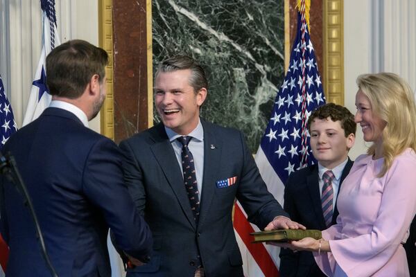 Vice President JD Vance, from left, swears in Pete Hegseth to be Secretary of Defense as his wife Jennifer Rauchet holds the Bible and Hegseth's son watches in the Indian Treaty Room of the Eisenhower Executive Office Building on the White House campus in Washington, Saturday, Jan. 25, 2025. (AP Photo/Rod Lamkey, Jr.)