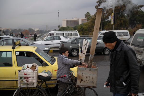 A boy prepares peanuts on his bicycle to sale on the street in Damascus, Syria, Sunday, Dec. 29, 2024. (AP Photo/Leo Correa)