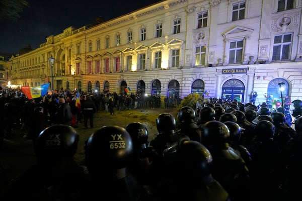 Police officers and supporters of Calin Georgescu face-off during a protest after Romania's electoral body rejected his candidacy in the presidential election rerun in Bucharest, Romania, Sunday, March 9, 2025. (AP Photo/Andreea Alexandru)