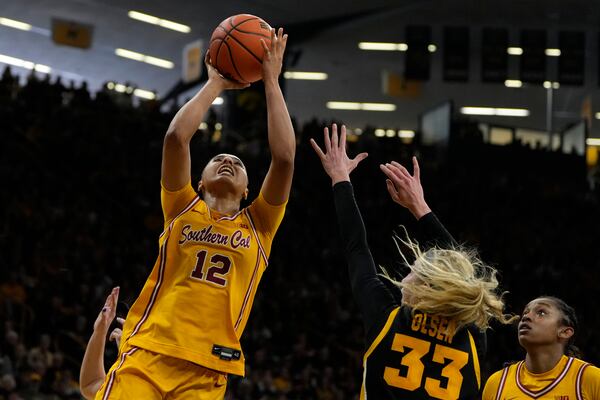 Southern California guard JuJu Watkins (12) drives to the basket over Iowa guard Lucy Olsen (33) during the first half of an NCAA college basketball game, Sunday, Feb. 2, 2025, in Iowa City, Iowa. (AP Photo/Charlie Neibergall)