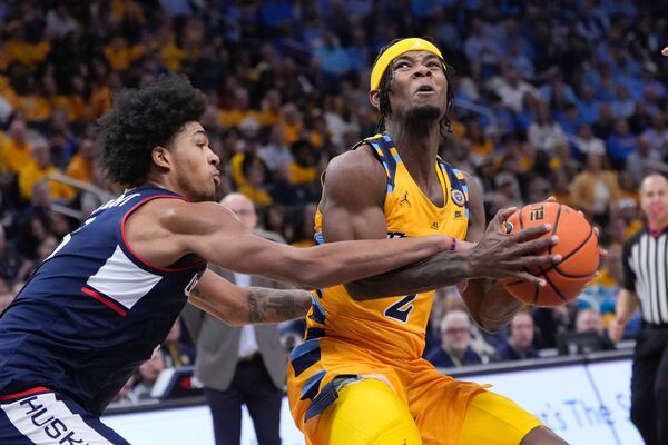 Marquette's Chase Ross is fouled by UConn's Jaylin Stewart during the first half of an NCAA college basketball game Saturday, Feb. 1, 2025, in Milwaukee. (AP Photo/Morry Gash)