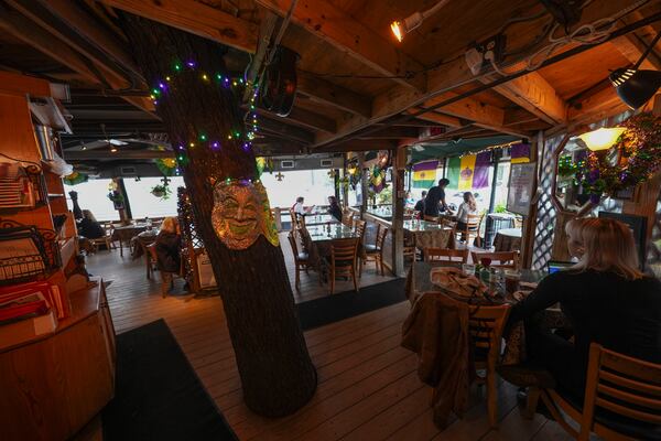 A tree trunk extends through the dining room at Cafe Degas near City Park in New Orleans, Wednesday, Jan. 29, 2025. (AP Photo/Gerald Herbert)