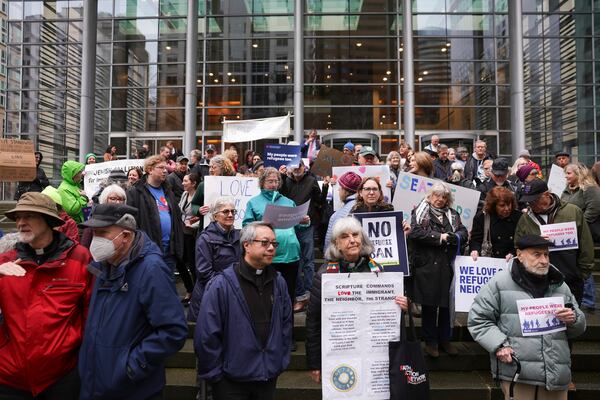 People gather outside the U.S. District Court after a federal judge blocked President Donald Trump's effort to halt the nation's refugee admissions system Tuesday, Feb. 25, 2025, in Seattle. (AP Photo/Ryan Sun)