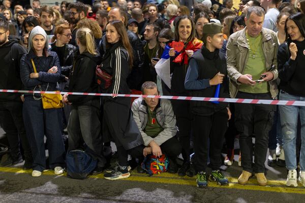 A man sits as he and others await the arrival of university students at a protest ahead of a major anti-corruption rally this weekend, in Belgrade, Serbia, Friday, March 14, 2025. (AP Photo/Marko Drobnjakovic)