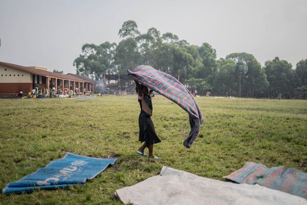 Esther, 10, daughter of Zawadi Sifa,dries blankets in her latest displaced camp in Goma, Democratic Republic of the Congo, Thursday, Feb. 5, 2025.(AP Photo/Moses Sawasawa)