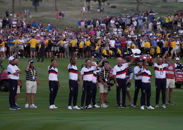 FILE - Members off the United States Ryder Cup team cheer United States' Patrick Cantlay after he won his afternoon Fourballs match on the 18th green at the Ryder Cup golf tournament at the Marco Simone Golf Club in Guidonia Montecelio, Italy, Sept. 30, 2023. (AP Photo/Alessandra Tarantino, file)