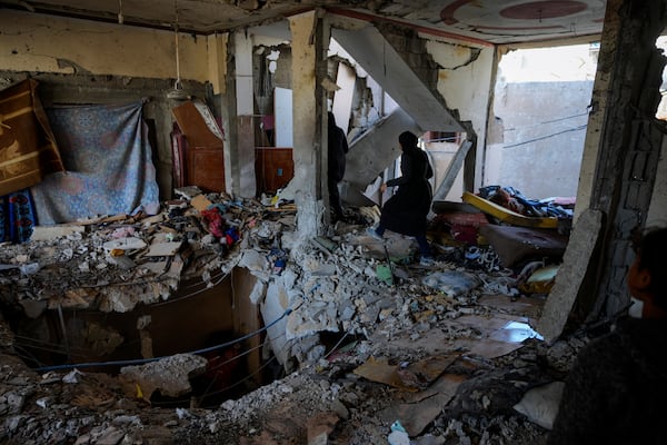 Palestinian women look at a damaged residential building following an overnight Israeli strike in Deir al-Balah, Gaza Strip, Thursday, Jan. 9, 2025. (AP Photo/Abdel Kareem Hana)