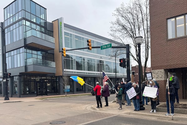 Protesters gather outside Rep. Bill Huizenga's office in Holland, Mich., on Friday, March 7, 2025, to protest the Republican not holding an in-person town hall. (AP Photo/Joey Cappelletti)