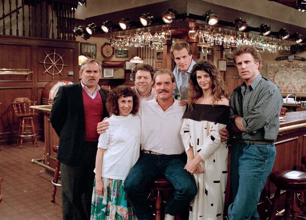 FILE -Boston Red Sox third baseman Wade Boggs, center, poses, March 2, 1988, with the cast of "Cheers" during rehearsal for an episode in which he appears. Cast members include, John Ratzenberger, Rhea Perlman, George Wendt, Woody Harrelson, Kirstie Alley and Ted Danson. (AP Photo/Ira Mark Gostin, File)