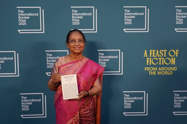 Banu Mushtaq, author of 'Heart Lamp' holds her book as she poses for photographers upon arrival for the International Booker Prize, in London, Tuesday, May 20, 2025.(AP Photo/Alberto Pezzali)