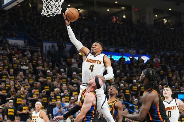 Denver Nuggets guard Russell Westbrook (4) leaps to the basket for a shot as Oklahoma City Thunder's Alex Caruso, bottom center, defends in the first half of Game 2 in the conference semifinals of the NBA basketball playoffs, Wednesday, May 7, 2025, in Oklahoma City. (AP Photo/Kyle Phillips)