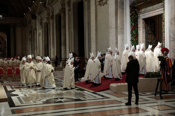 Members of the clergy walk after Pope Francis opened the Holy Door to mark the opening of the 2025 Catholic Holy Year, or Jubilee, in St. Peter's Basilica, at the Vatican, Tuesday Dec. 24, 2024. (Remo Casilli/Pool via AP)