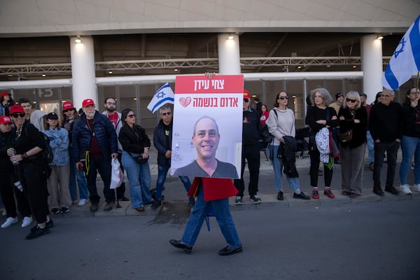 People attend a public memorial ceremony for slain hostage Tsachi Idan, a fan of Hapoel Tel Aviv F.C., who was killed in Hamas captivity in the Gaza Strip, outside the Bloomfield Stadium in Tel Aviv, Israel, Friday, Feb. 28, 2025. (AP Photo/Leo Correa)