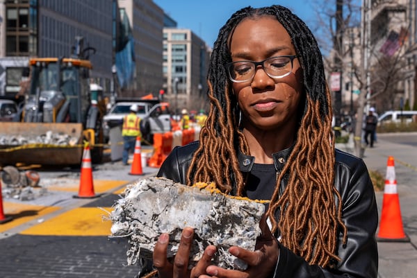 Tears roll down the face of Starlette Thomas, of Bowie, Md., as she holds a chunk of pavement from the Black Lives Matter mural, Monday, March 10, 2025, as the mural begins to be demolished in Washington. "I needed to be here to bear witness," says Thomas, who was present at the 2020 George Floyd protests. "For me the Black Lives Matter sign etched in stone was a declaration of somebodyness and to watch it be undone in this way was very hurtful. To walk away with a piece of that, it means it's not gone. It's more than brick and mortar." (AP Photo/Jacquelyn Martin)