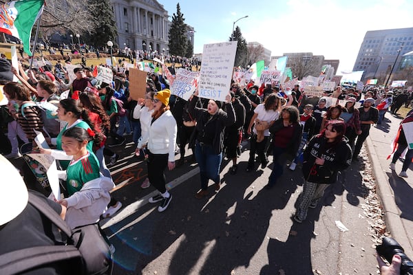 Participants walk down Lincoln Street during a political protest outside the State Capitol Wednesday, Feb. 5, 2025, in Denver. (AP Photo/David Zalubowski)