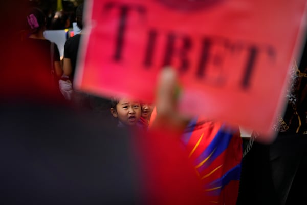 Tibetan children watch their parents shout slogans during a protest to commemorate the 1959 uprising in Tibet against the Chinese rule, in New Delhi, India, Monday, March, 10, 2025. (AP Photo/Manish Swarup)