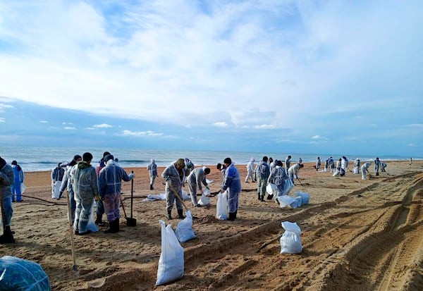 In this photo released by Krasnodar Gov. Veniamin Kondratyev in his Telegram channel on Sunday, Jan. 5, 2025, rescuers and volunteers work to clean up tons of fuel oil that spilled out of two storm-stricken tankers more than two weeks ago in the Kerch Strait, near Anapa in Russia's southern Krasnodar region. (Krasnodar Gov. Veniamin Kondratyev Telegram channel via AP)