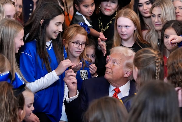 President Donald Trump hands out pens after signing an executive order barring transgender female athletes from competing in women's or girls' sporting events, in the East Room of the White House, Wednesday, Feb. 5, 2025, in Washington. (AP Photo/Alex Brandon)