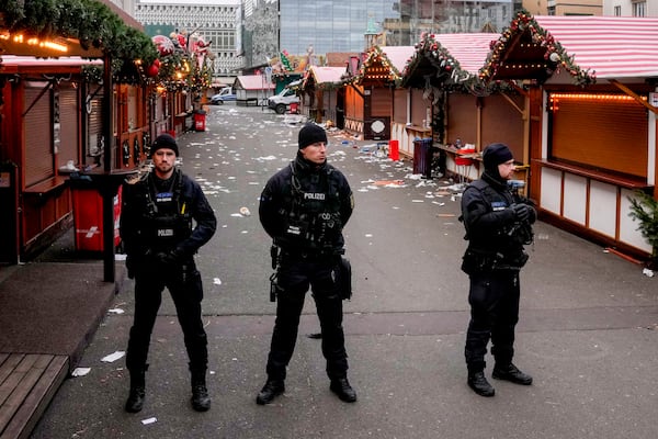 Policemen guard a Christmas Market, where a car drove into a crowd on Friday evening, in Magdeburg, Germany, Saturday, Dec. 21, 2024. (AP Photo/Michael Probst)