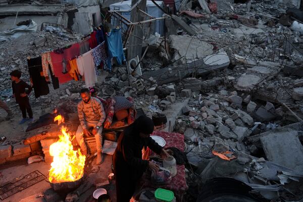 Members of Palestinian Marouf family cook outside their destroyed house by the Israeli army's air and ground offensive in Jabaliya, Gaza Strip, on Monday, March 17, 2025. (AP Photo/Jehad Alshrafi)