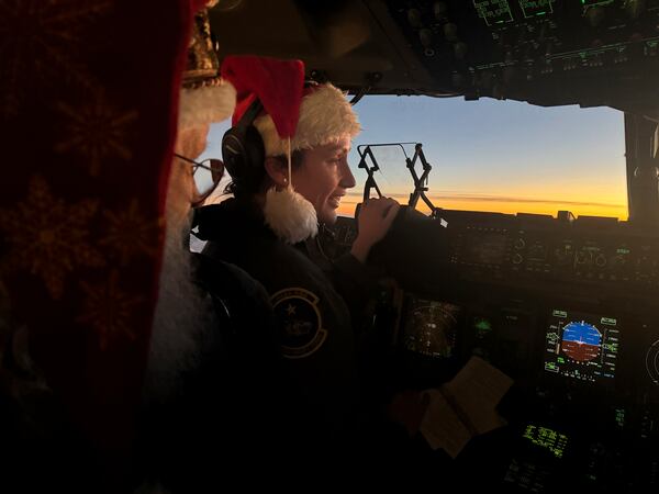 Santa Claus speaks to pilot Maj. Lauren Schumacher en route to Yakutat, Alaska, as part of the Alaska National Guard's Operation Santa initiative that brings Christmas to an Indigenous community that has suffered a hardship, Wednesday, Dec. 18, 2024,. (AP Photo/Mark Thiessen)