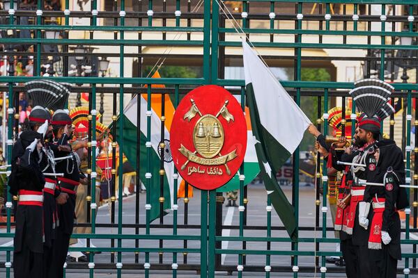 Pakistan's Rangers soldiers, in black, and Indian Border Security Forces soldiers, lower their flags during a daily closing ceremony at the Wagah, a joint post on the Pakistan and India border, near Lahore, Pakistan, Saturday, May 3, 2025. (AP Photo/K.M. Chaudary)