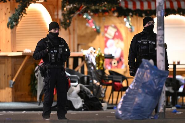 Police stand at a Christmas market in Magdeburg, Germany, early Saturday, Dec. 21, 2024, after a driver plowed into a group of people at the market late Friday. (Hendrik Schmidt/dpa via AP)