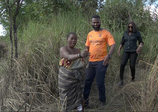 This image taken from video Wednesday, Feb. 19, 2025, shows farmer Juliet Balaya as she surveys the damage to her crop and fishpond caused by a mine waste spill near Kitwe. (AP Photo/Richard Kille )