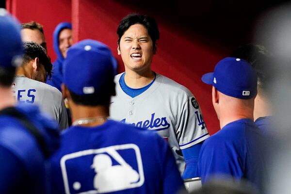 Los Angeles Dodgers' Shohei Ohtani celebrates in the dugout after his three-run home run against the Arizona Diamondbacks during the ninth inning of a baseball game Friday, May 9, 2025, in Phoenix. (AP Photo/Darryl Webb)