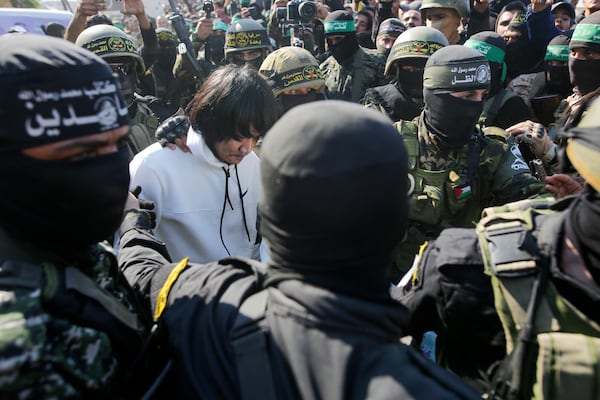 One of five Thai hostages, who has been held hostage by Hamas in Gaza since October 7, 2023, is escorted by Hamas and Islamic Jihad fighters as he is handed over to the Red Cross in Khan Younis, southern Gaza Strip, Thursday Jan. 13, 2025.(AP Photo/Jehad Alshrafi)