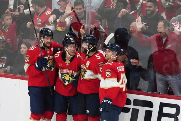 Florida Panthers center Jesper Boqvist (70) celebrates with Aleksander Barkov (16), Aaron Ekblad (5) and Gustav Forsling (42) after scoring a goal against the Carolina Hurricanes during the third period in Game 3 of the NHL hockey Stanley Cup Eastern Conference finals Saturday, May 24, 2025, in Sunrise, Fla. (AP Photo/Lynne Sladky)