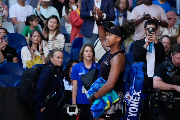 Naomi Osaka of Japan waves as she leaves the court after retiring from her third round match against Belinda Bencic of Switzerland at the Australian Open tennis championship in Melbourne, Australia, Friday, Jan. 17, 2025. (AP Photo/Manish Swarup)