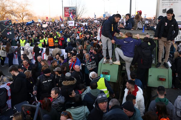 People climb up a tractor during a protest over the collapse of a concrete canopy that killed 15 people more than two months ago, in Novi Sad, Serbia, Saturday, Feb. 1, 2025. (AP Photo/Armin Durgut)