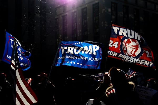 Demonstrators wave flags outside Manhattan criminal court following the sentencing in President-elect Donald Trump's hush money case, Friday, Jan. 10, 2025, in New York. (AP Photo/Julia Demaree Nikhinson)