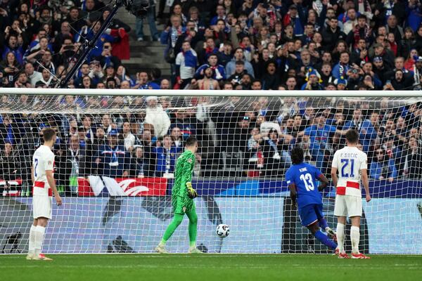 Croatia's goalkeeper Dominik Livakovic, center, watches the ball go into the net for a goal by France's Michael Olise during the UEFA Nations League quarterfinal second leg soccer match between France and Croatia, at the Stade de France in Saint-Denis, outside Paris, Sunday, March 23, 2025. (AP Photo/Thibault Camus)