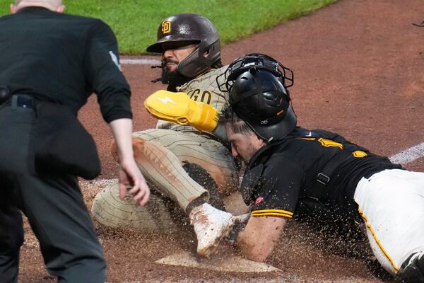 San Diego Padres' Fernando Tatis Jr., left, scores before Pittsburgh Pirates catcher Joey Bart can apply the tag on a wild pitch by pitcher David Bednar during the ninth inning of a baseball game in Pittsburgh, Saturday, May 3, 2025. (AP Photo/Gene J. Puskar)
