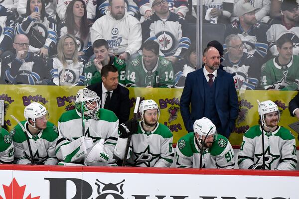 Dallas Stars goaltender Jake Oettinger (29) sits on the bench for an extra attacker against the Winnipeg Jets during the third period of an NHL hockey playoff game in Winnipeg, Manitoba, Friday, May 9, 2025. (Fred Greenslade/The Canadian Press via AP)