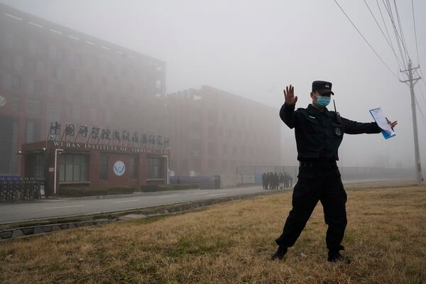 FILE - A security person moves journalists away from the Wuhan Institute of Virology after a World Health Organization team arrived for a field visit in Wuhan in China's Hubei province, Feb. 3, 2021. (AP Photo/Ng Han Guan, File)