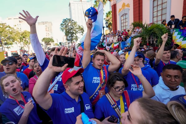 Russians visiting Venezuela cheer outside Miraflores presidential palace as President Nicolas Maduro speaks to supporters on his inauguration day for a third term in Caracas, Venezuela, Friday, Jan. 10, 2025. (AP Photo/Matias Delacroix)